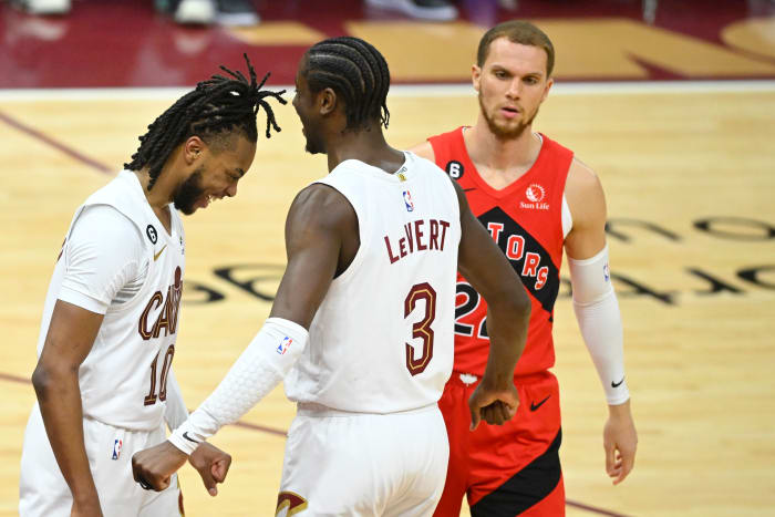 Feb 26, 2023; Cleveland, Ohio, USA; Cleveland Cavaliers guard Darius Garland (10) and guard Caris LeVert (3) celebrate beside Toronto Raptors guard Malachi Flynn (22) in the fourth quarter at Rocket Mortgage FieldHouse. Mandatory Credit: David Richard-USA TODAY Sports